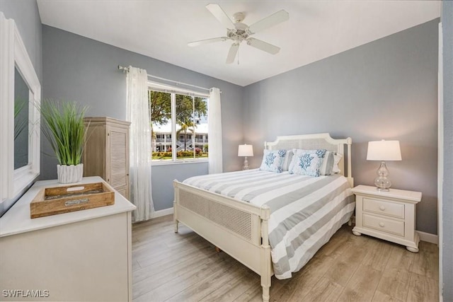bedroom featuring light wood-style floors, baseboards, and a ceiling fan
