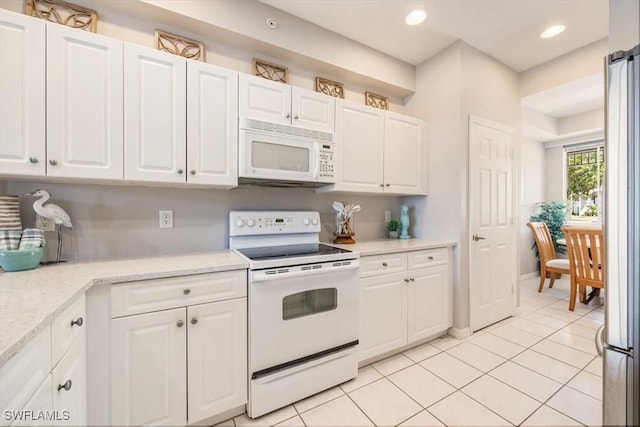 kitchen with white appliances, white cabinets, light tile patterned floors, recessed lighting, and baseboards