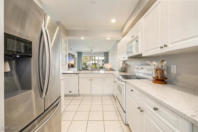 kitchen with white appliances, light tile patterned flooring, white cabinetry, a ceiling fan, and light stone countertops