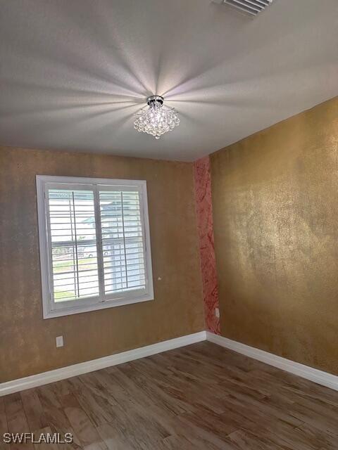 unfurnished room featuring wood finished floors and baseboards