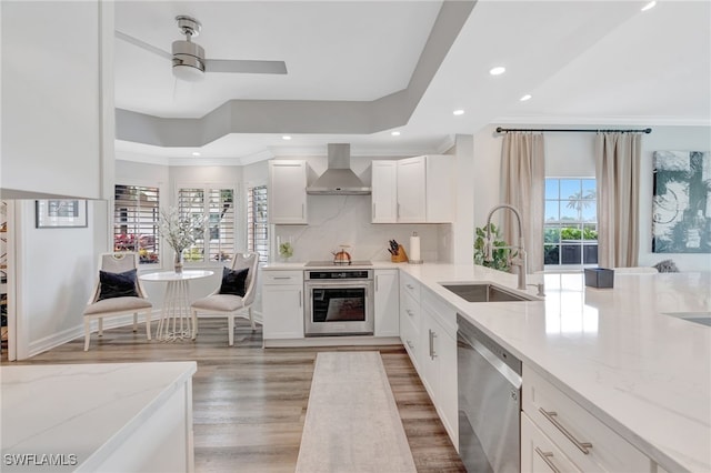 3580 Windjammer Cir Unit 1603, Naples, FL 34112 - kitchen featuring stainless steel appliances, a sink, wall chimney exhaust hood, light stone counters, and backsplash
