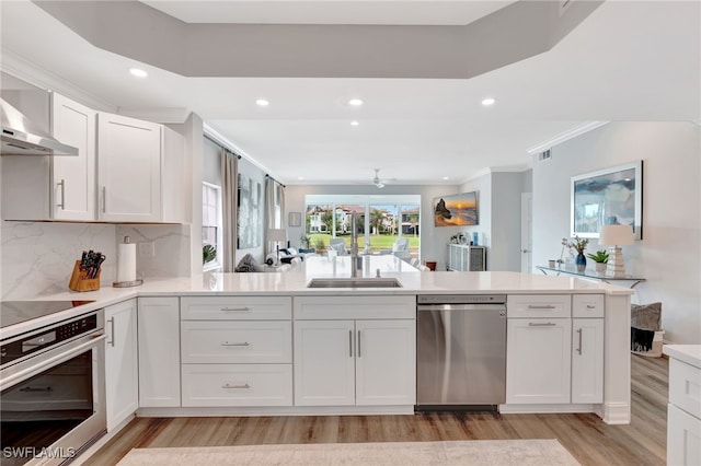 3580 Windjammer Cir Unit 1603, Naples, FL 34112 - kitchen with stainless steel appliances, a sink, recessed lighting, light wood-style flooring, and white cabinets