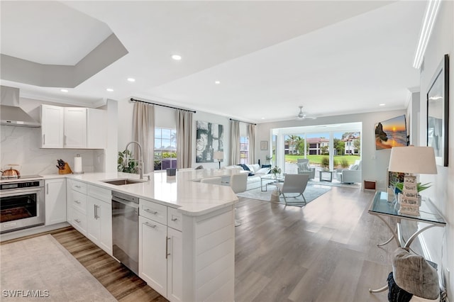 3580 Windjammer Cir Unit 1603, Naples, FL 34112 - kitchen with a sink, appliances with stainless steel finishes, open floor plan, light wood finished floors, and a peninsula