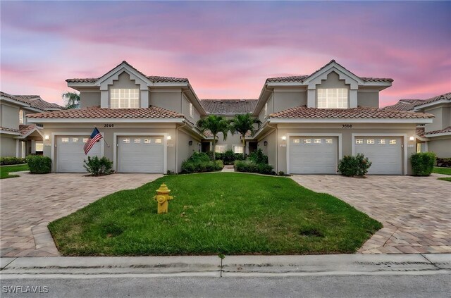 3580 Windjammer Cir Unit 1603, Naples, FL 34112 - view of front of house featuring a front yard, decorative driveway, stucco siding, a tile roof, and an attached garage