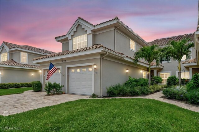 3580 Windjammer Cir Unit 1603, Naples, FL 34112 - mediterranean / spanish home with stucco siding, a front lawn, a tile roof, decorative driveway, and a garage