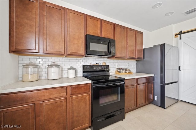 8118 Gopher Tortoise Trl, Lehigh Acres, FL 33972 - kitchen with black appliances, light countertops, backsplash, and a barn door