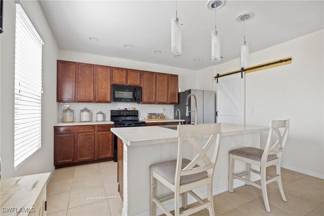 8118 Gopher Tortoise Trl, Lehigh Acres, FL 33972 - kitchen with black appliances, a barn door, light countertops, tasteful backsplash, and light tile patterned flooring