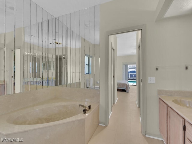bathroom featuring ensuite bathroom, a garden tub, and vanity