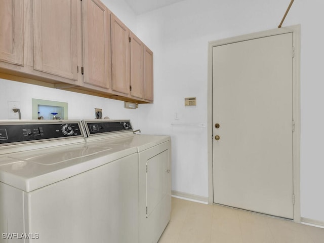 laundry area with washing machine and dryer, cabinet space, and baseboards