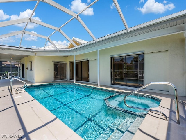 view of swimming pool with a pool with connected hot tub, a patio area, and glass enclosure