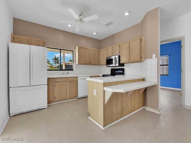 kitchen with white appliances, decorative backsplash, a peninsula, a sink, and ceiling fan