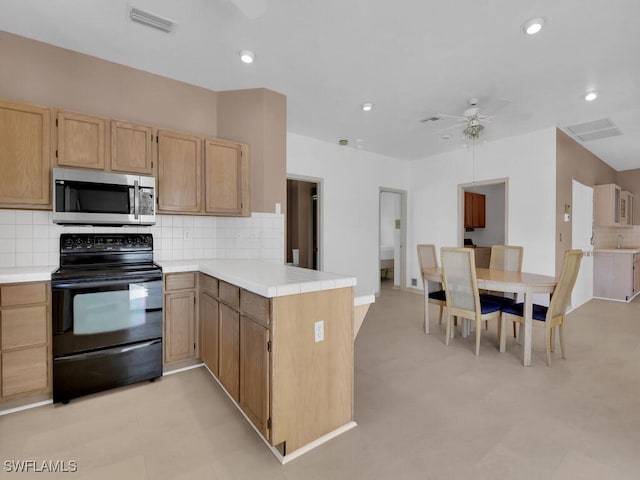 kitchen with stainless steel microwave, black range with electric cooktop, a peninsula, a ceiling fan, and decorative backsplash