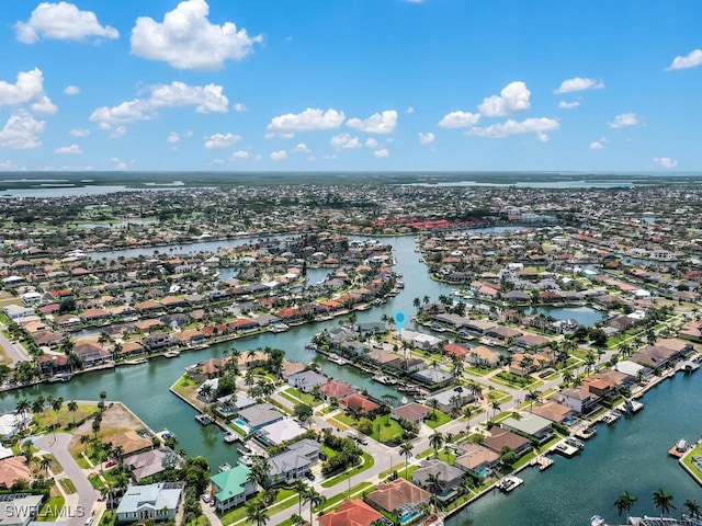 aerial view of property and surrounding area featuring nearby suburban area and a large body of water