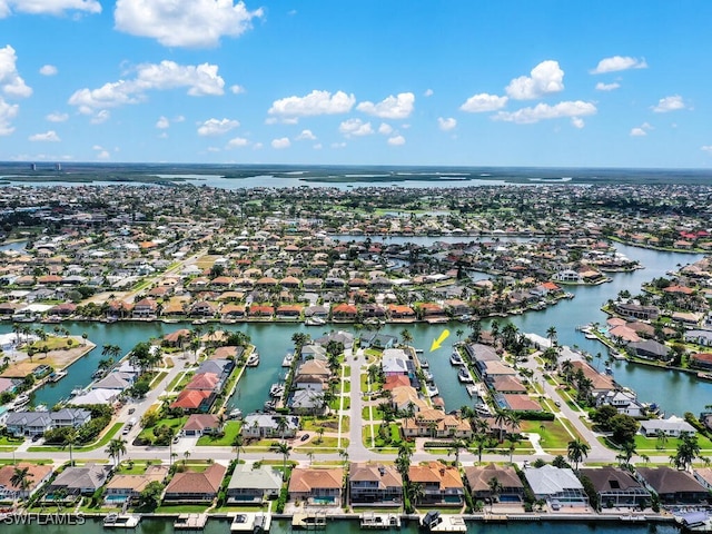 aerial view of property and surrounding area with nearby suburban area and a large body of water