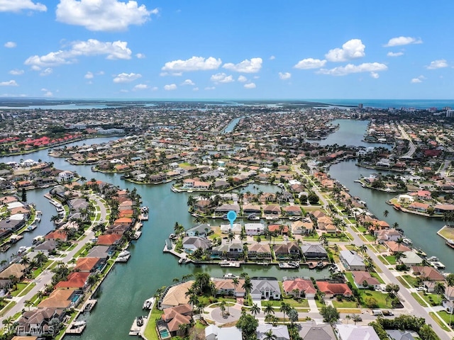aerial view of property and surrounding area featuring nearby suburban area and a nearby body of water
