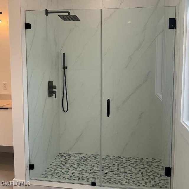 bathroom featuring a marble finish shower