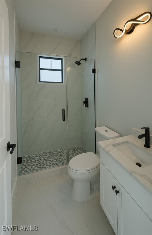 full bath featuring toilet, a stall shower, and vanity