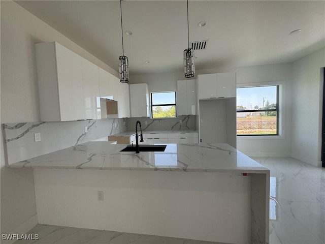 kitchen featuring a sink, modern cabinets, white cabinets, light marble finish floors, and decorative backsplash