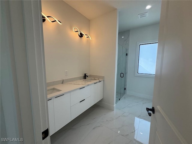 full bath with a marble finish shower, marble finish floors, baseboards, double vanity, and recessed lighting