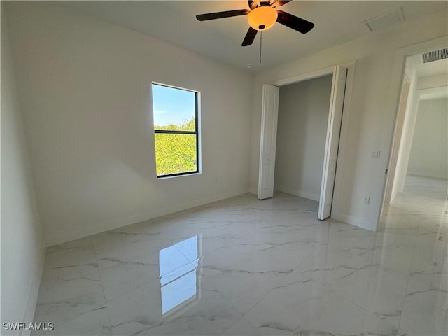 unfurnished bedroom featuring baseboards, light marble finish flooring, and ceiling fan