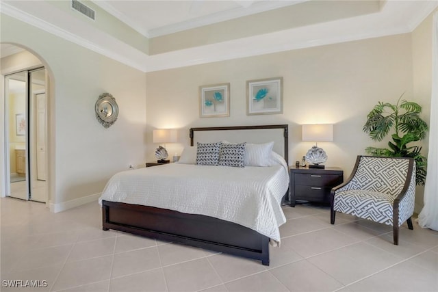 tiled bedroom featuring crown molding, arched walkways, and baseboards
