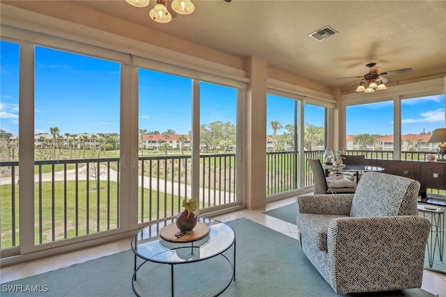 sunroom featuring tile patterned floors and a residential view