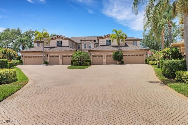 mediterranean / spanish-style home featuring decorative driveway, an attached garage, and stucco siding