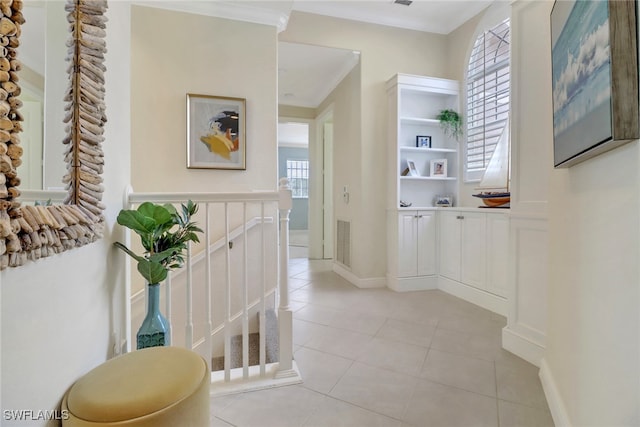 hallway with light tile patterned floors and ornamental molding