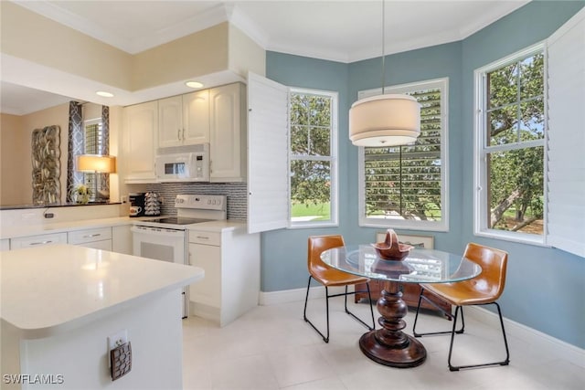 kitchen featuring white appliances, baseboards, tasteful backsplash, light countertops, and crown molding