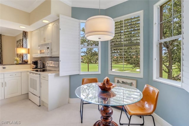 dining space featuring baseboards, crown molding, and recessed lighting
