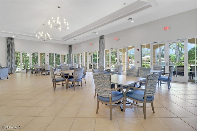dining area featuring a raised ceiling, light tile patterned floors, recessed lighting, a high ceiling, and a chandelier