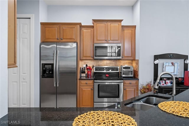 11265 Suffield St, Fort Myers, FL 33913 - kitchen with stainless steel appliances, a sink, decorative backsplash, dark stone counters, and brown cabinetry