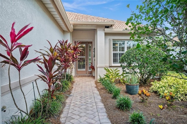 11265 Suffield St, Fort Myers, FL 33913 - view of exterior entry with stucco siding and a tiled roof