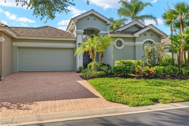 3417 Marbella Ct, Bonita Springs, FL 34134 - view of front facade featuring stucco siding, decorative driveway, an attached garage, and a front yard