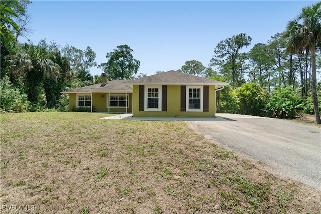 681 23rd St NW, Naples, FL 34120 - single story home featuring stucco siding, a front yard, and a chimney