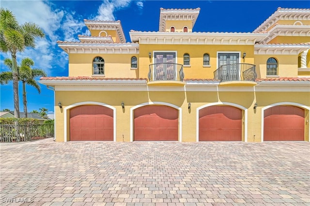 4910 SW 17th Pl Unit 4B, Cape Coral, FL 33914 - view of front of property with a balcony, french doors, stucco siding, and an attached garage