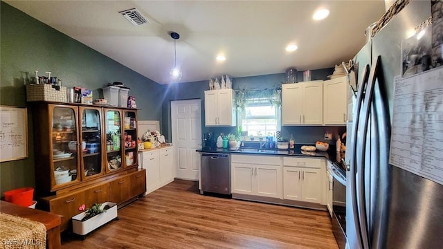 3086 E Briarwood Cir, Labelle, FL 33935 - kitchen with appliances with stainless steel finishes, white cabinetry, wood finished floors, a sink, and dark countertops