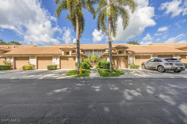 8015 Tiger Cv Unit 204, Naples, FL 34113 - view of front of property with stucco siding, a tiled roof, and community garages