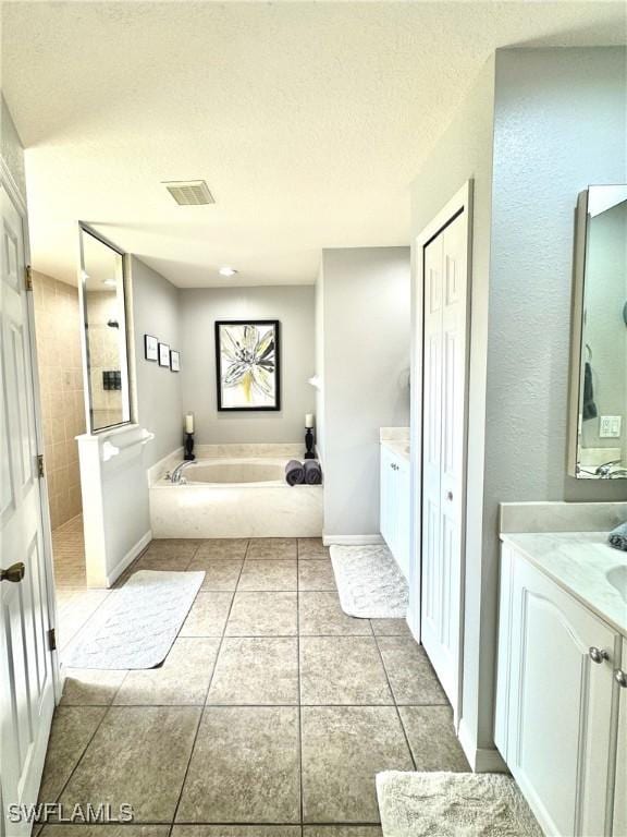 2639 SW 5th St, Cape Coral, FL 33991 - full bath featuring tile patterned floors, vanity, a bath, tiled shower, and a textured ceiling