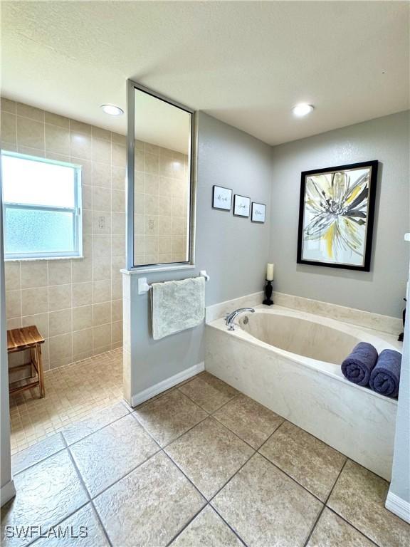 2639 SW 5th St, Cape Coral, FL 33991 - bathroom featuring a garden tub, walk in shower, tile patterned floors, and recessed lighting