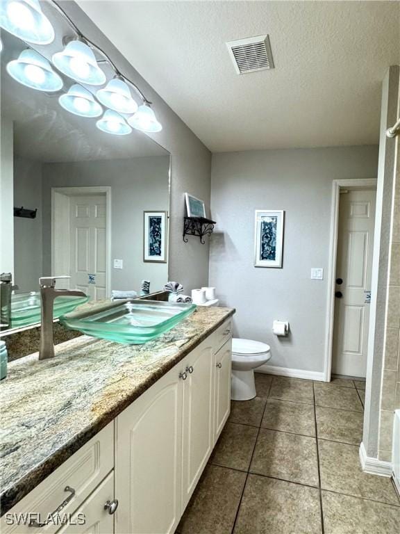 2639 SW 5th St, Cape Coral, FL 33991 - full bath with toilet, tile patterned flooring, a textured ceiling, vanity, and baseboards