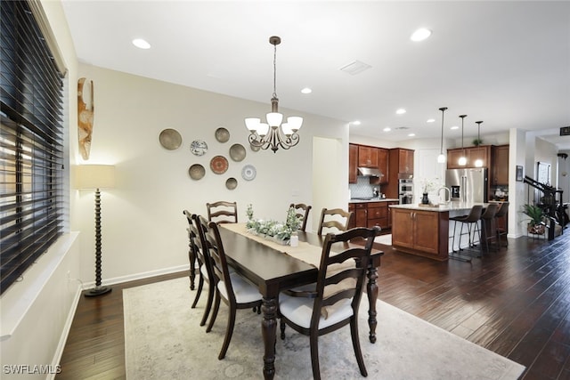 dining area with dark wood-style floors, a chandelier, recessed lighting, and baseboards