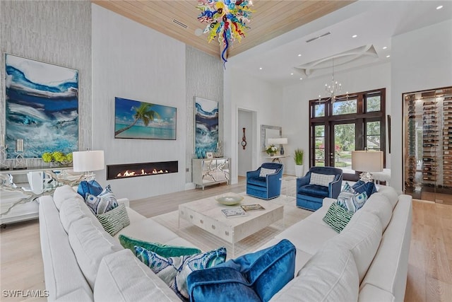 714 Killdeer Pl, Naples, FL 34108 - living room with a high ceiling, wood finished floors, recessed lighting, a fireplace, and a chandelier