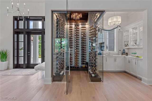 714 Killdeer Pl, Naples, FL 34108 - wine room featuring a chandelier, light wood-type flooring, a sink, and baseboards
