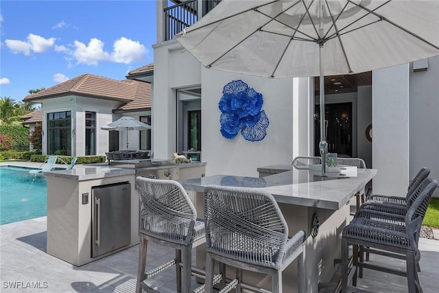 714 Killdeer Pl, Naples, FL 34108 - view of patio / terrace with a balcony, exterior kitchen, and an outdoor pool