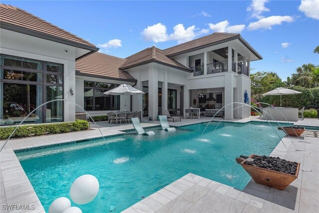 714 Killdeer Pl, Naples, FL 34108 - back of house featuring a balcony, a patio, an outdoor pool, and stucco siding