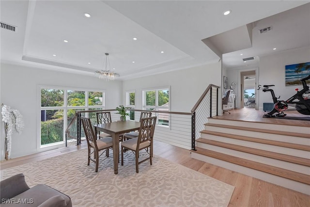 714 Killdeer Pl, Naples, FL 34108 - dining space featuring a raised ceiling, wood finished floors, a chandelier, recessed lighting, and stairway