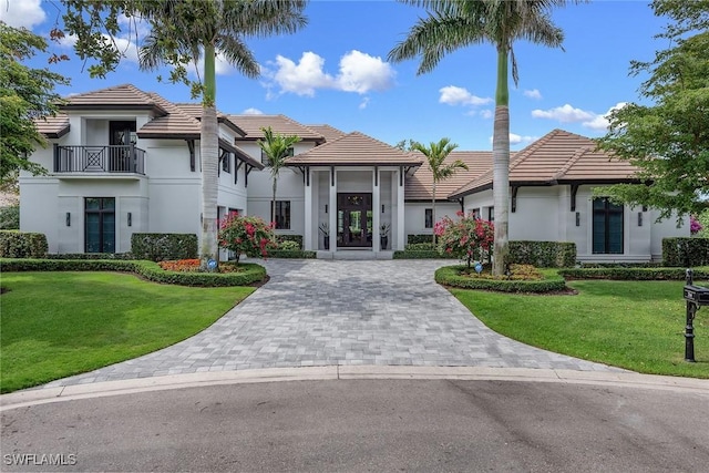714 Killdeer Pl, Naples, FL 34108 - view of front of house featuring a tile roof, decorative driveway, stucco siding, french doors, and a front lawn