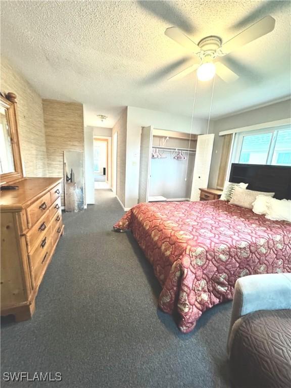 carpeted bedroom featuring a textured ceiling and ceiling fan
