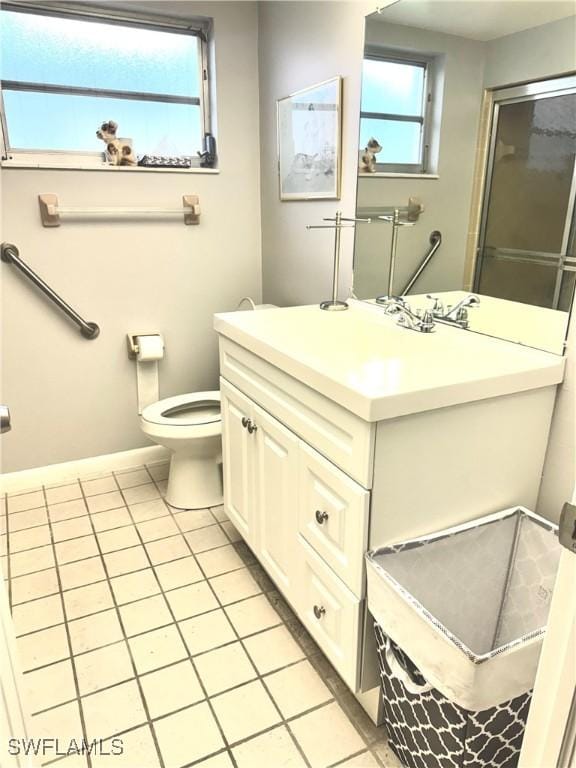 bathroom featuring toilet, tile patterned floors, baseboards, and vanity